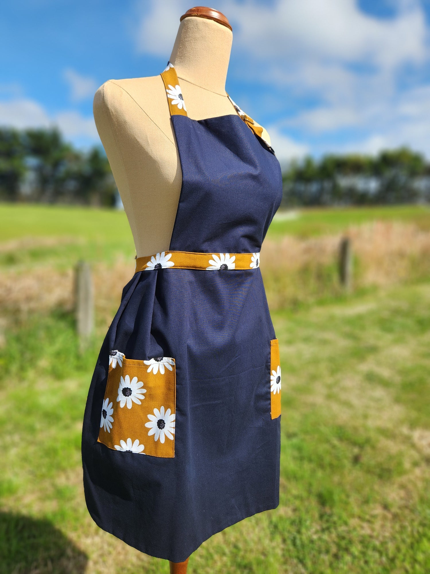 womens bib style apron in navy with mustard daisies