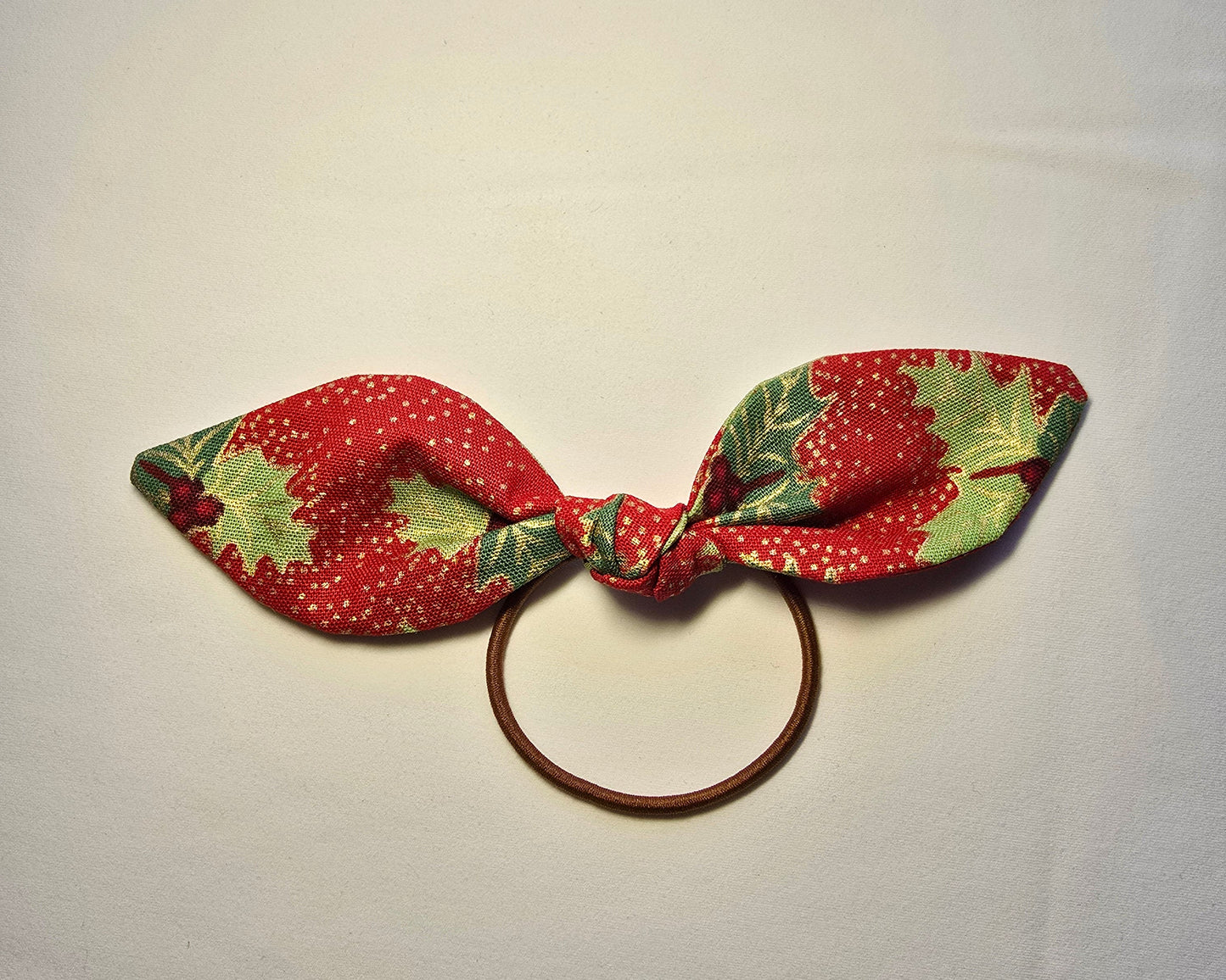 Fabric bow with red and green pattern on a white background