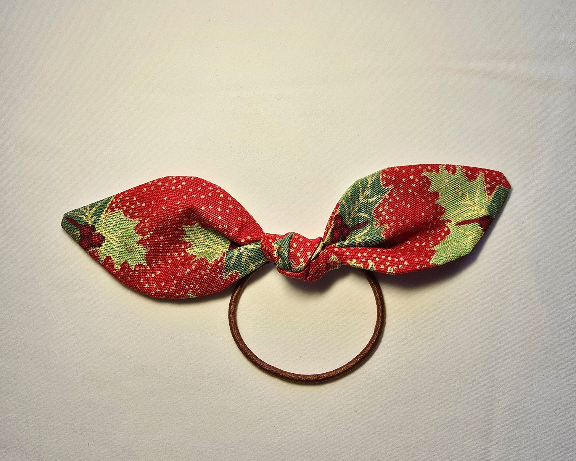 Fabric bow with red and green pattern on a white background